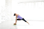 Yoga practitioner in side plank pose using Adidas cork yoga block for support