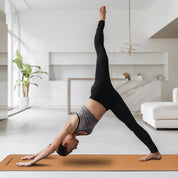 Three-legged downward dog pose on Powertrain Cork Yoga Mat for home gym Pilates