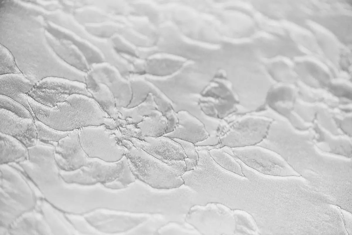 White fabric with raised floral pattern.