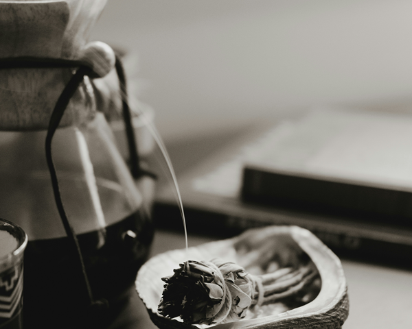 smoldering smudge stick in abalone shell dish