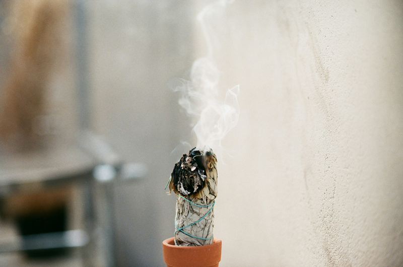 burning smudge stick in small terracotta holder