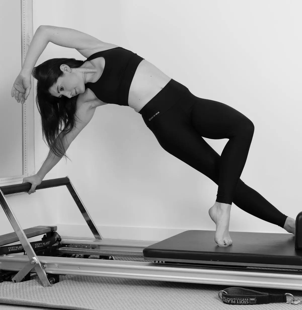 woman in black sports bra and black leggings doing yoga