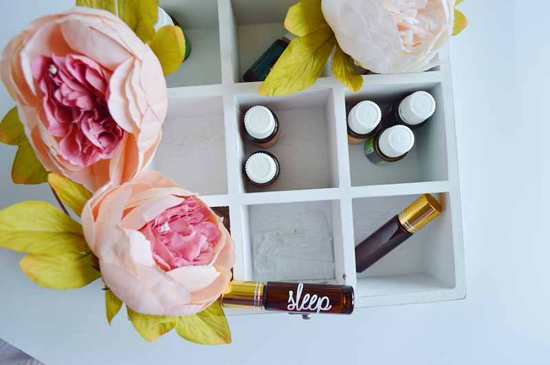 essential oils in a storage box next to flowers