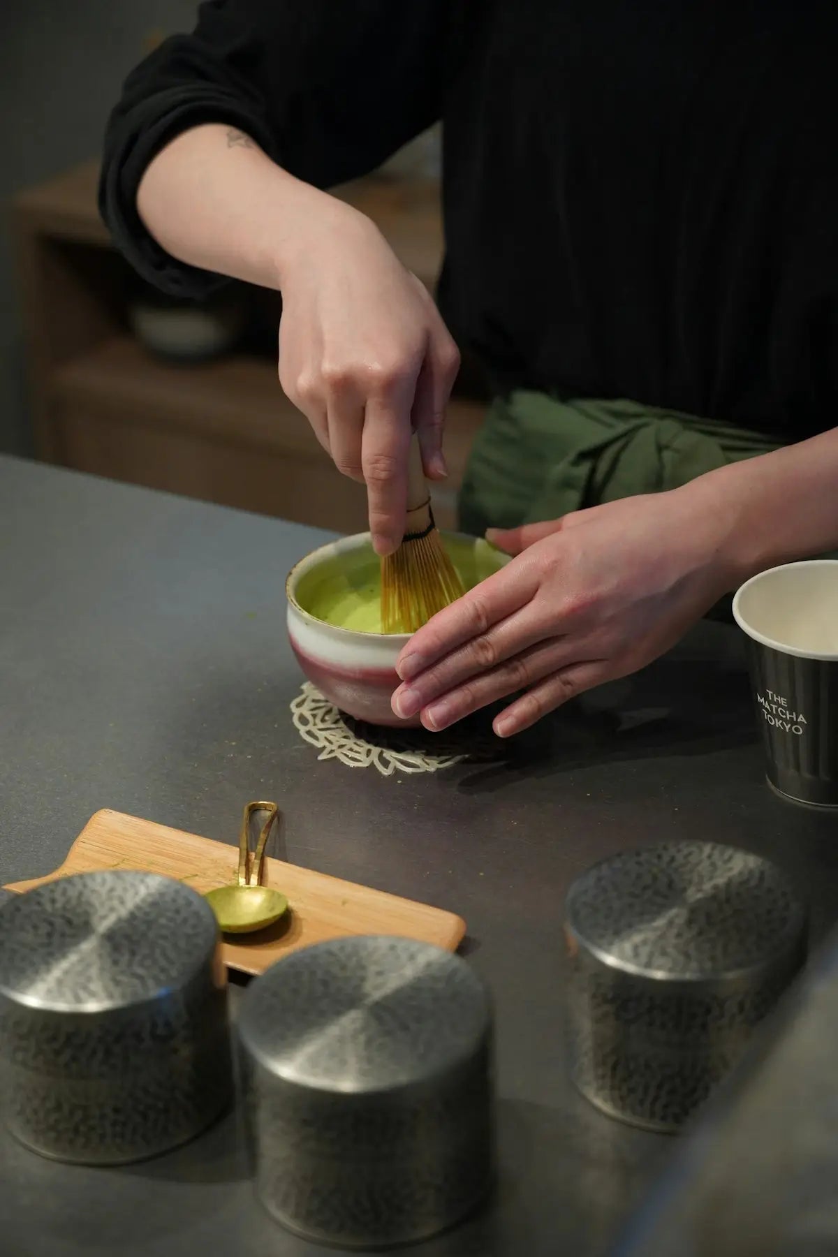 Someone is whisking matcha tea in a bowl.