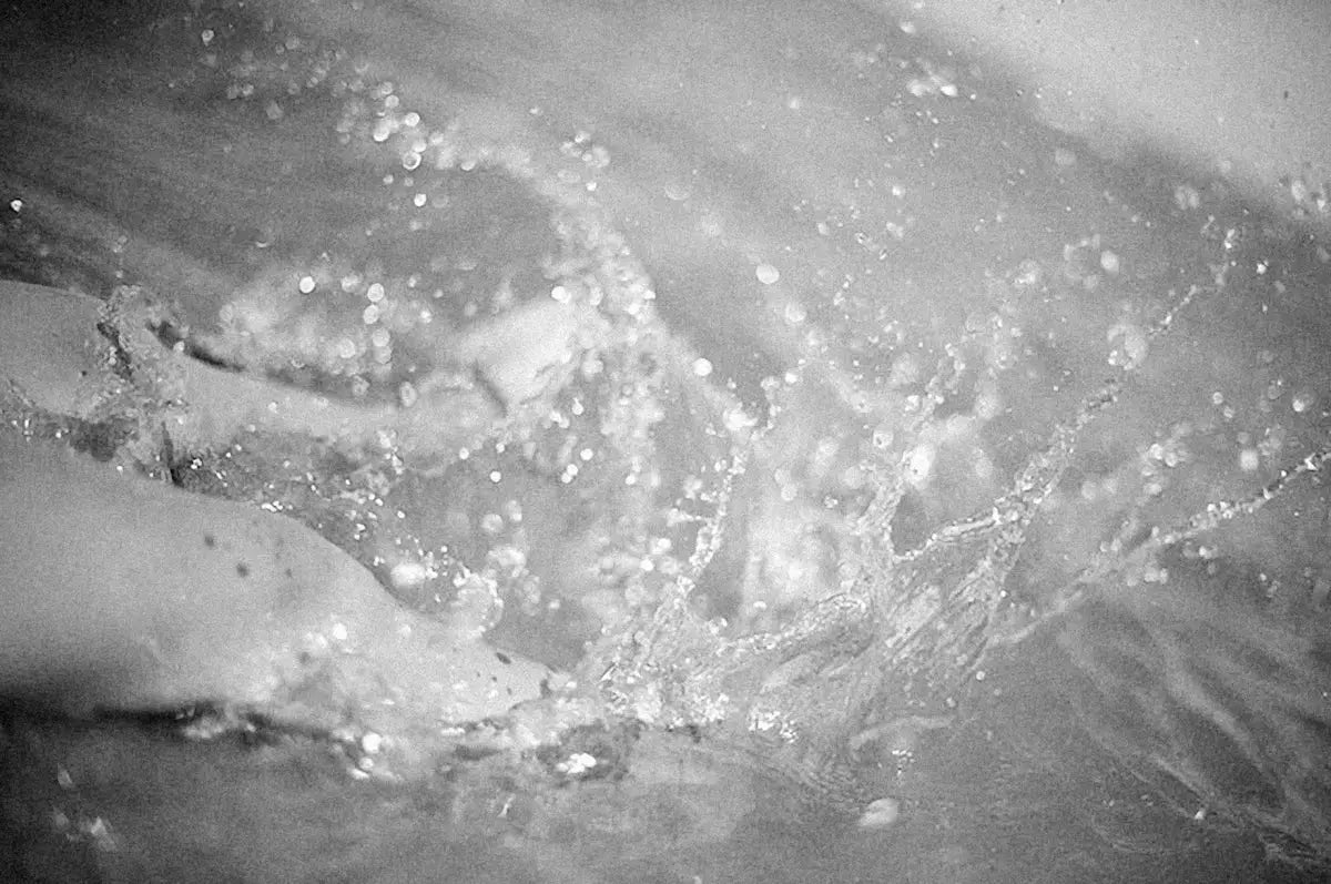 a black and white photo of a wave