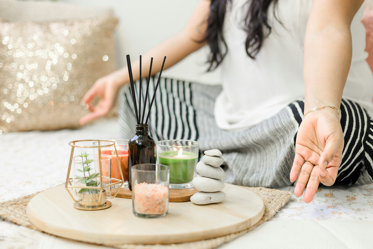 girl meditating on floor with candles