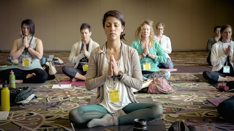 group of people sitting cross legged meditating