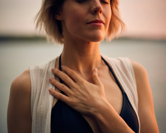 woman holding hand over heart and breathing