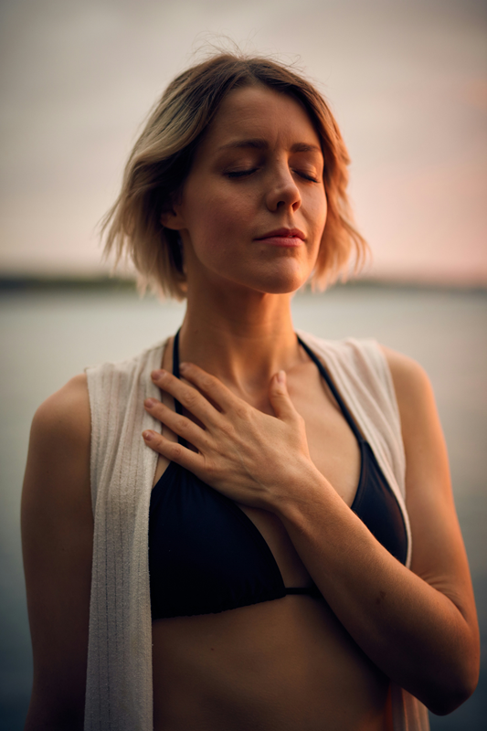 woman holding hand over heart and breathing