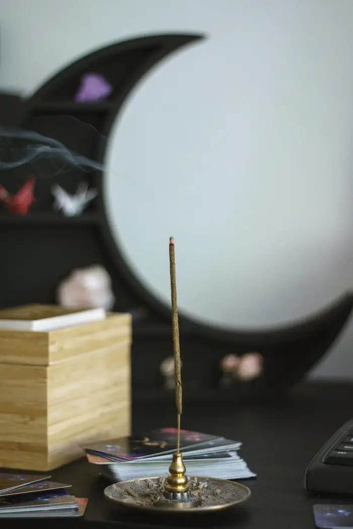 burning incense stick in front of moon