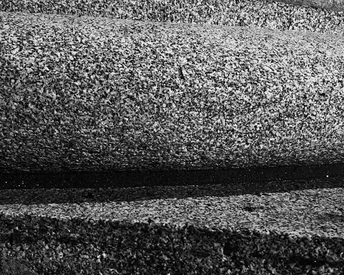 Textured gray surface with curved grooves.