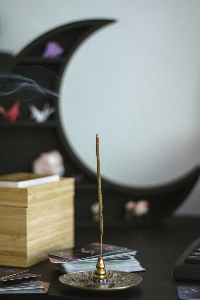 burning incense stick in front of moon