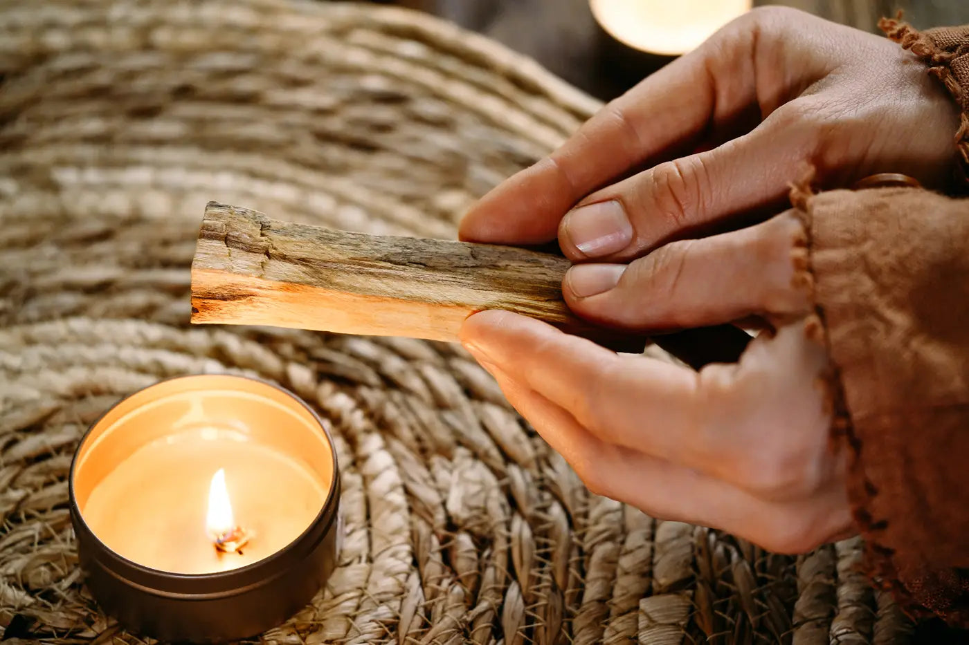 woman lighting palo santo with candle