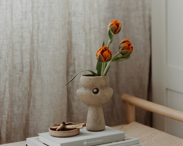 palo santo sticks in smudging bowl next to vase with flowers