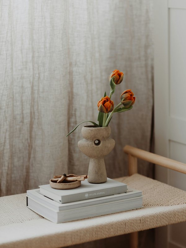 palo santo sticks in smudging bowl next to vase with flowers