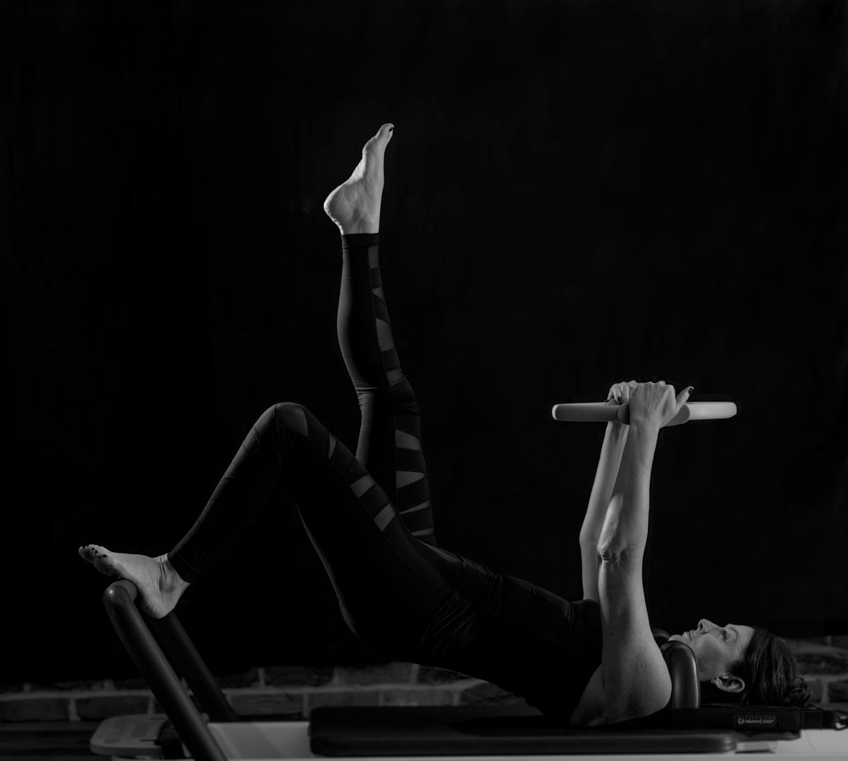 woman in black pants and black boots lying on black wooden bench