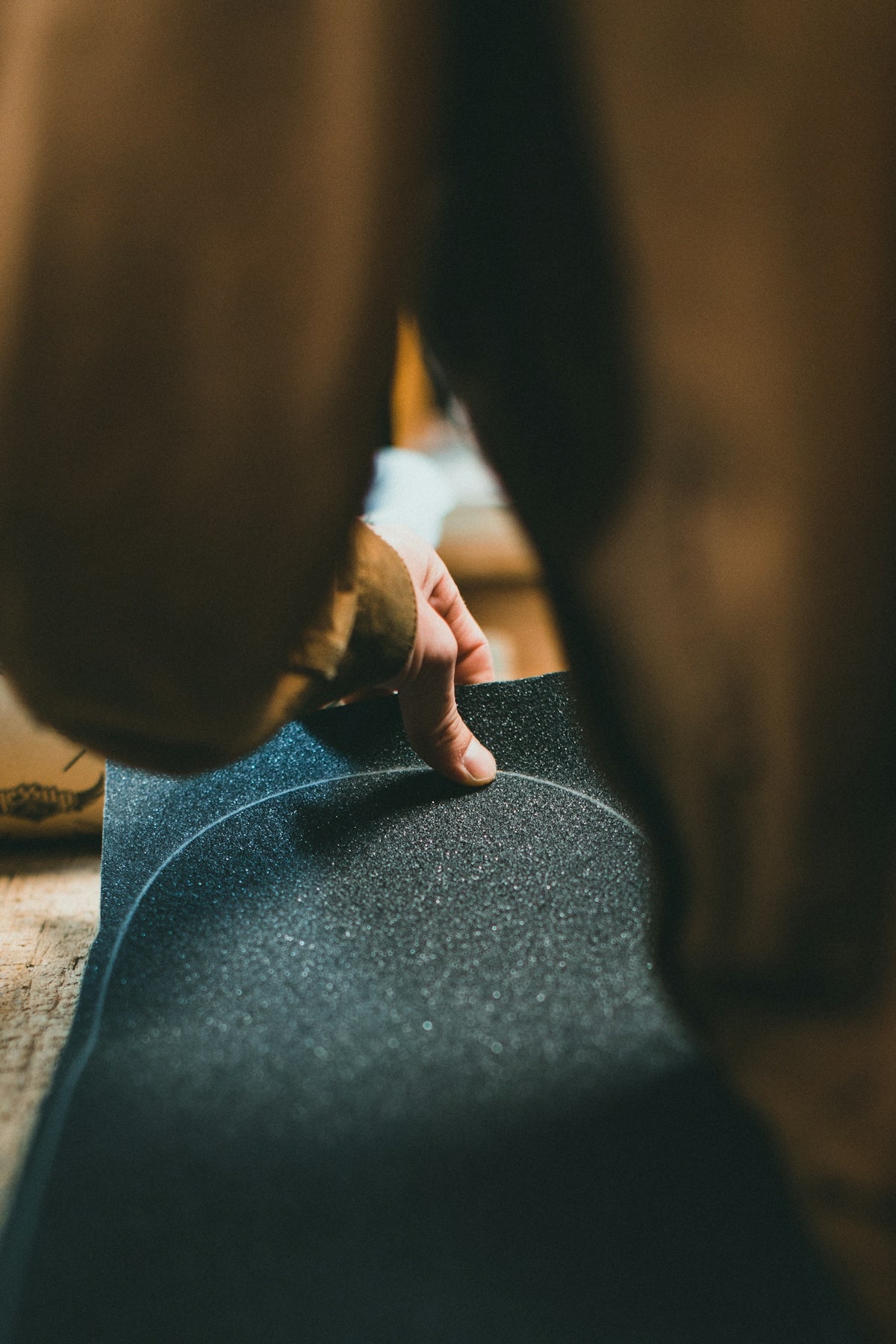 a person standing over a skateboard on a wooden floor