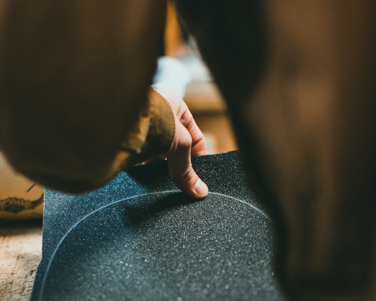 a person standing over a skateboard on a wooden floor