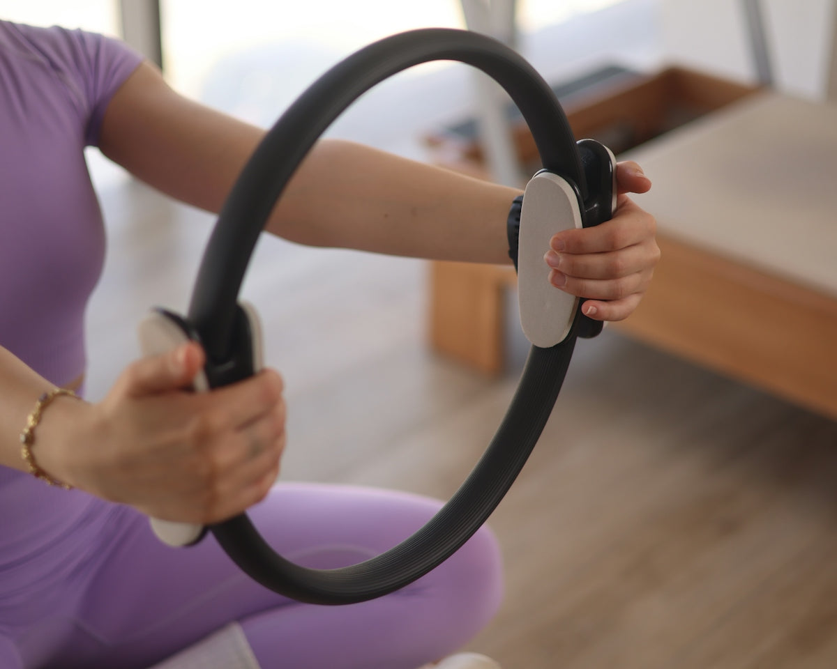 a woman sitting on the floor holding a steering wheel