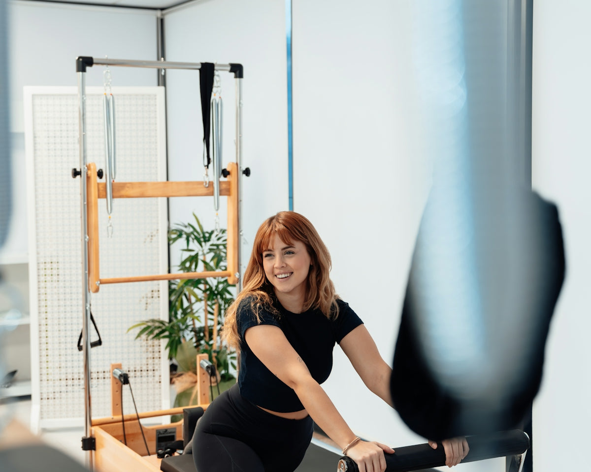 a woman is riding a stationary rowing machine