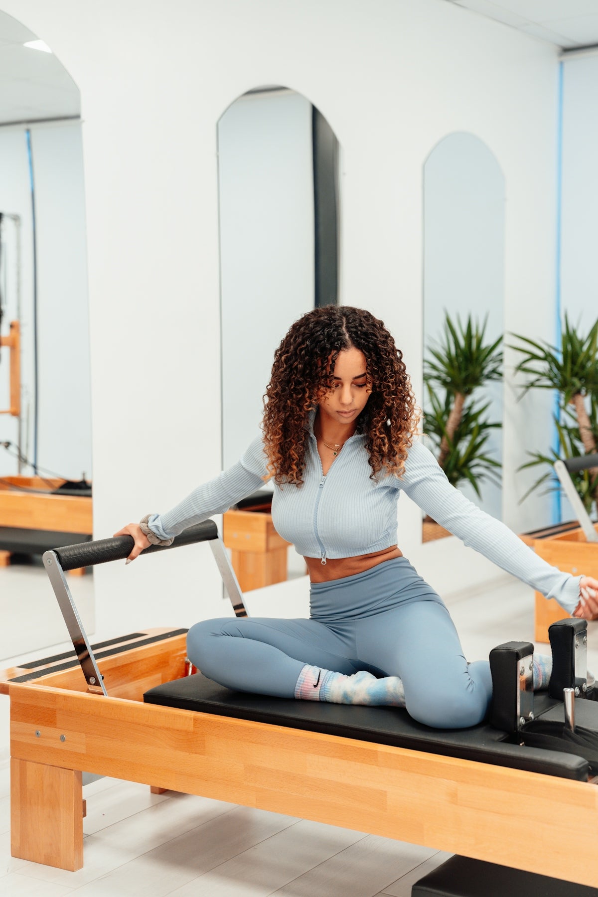 a woman sitting on a piyor in a gym