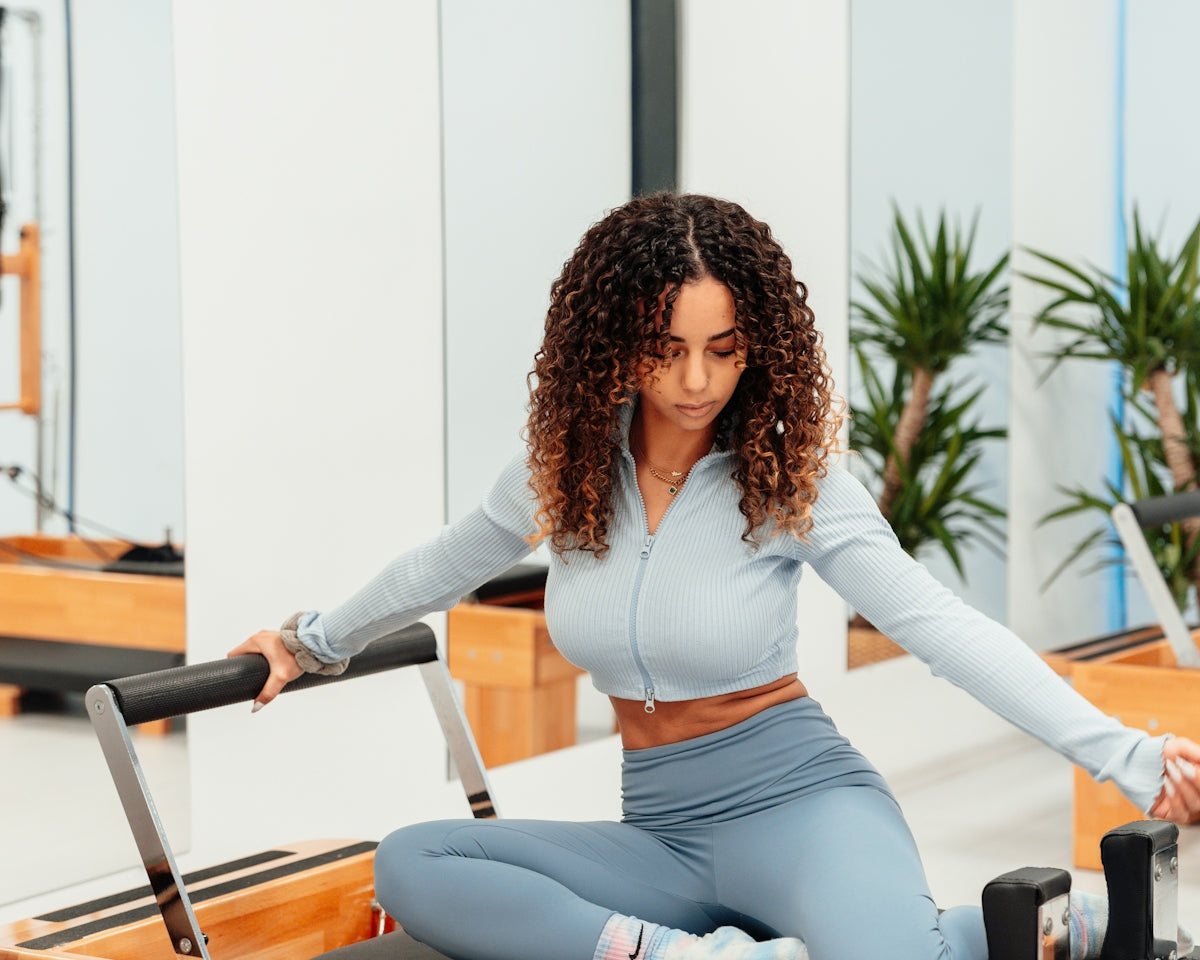 a woman sitting on a piyor in a gym