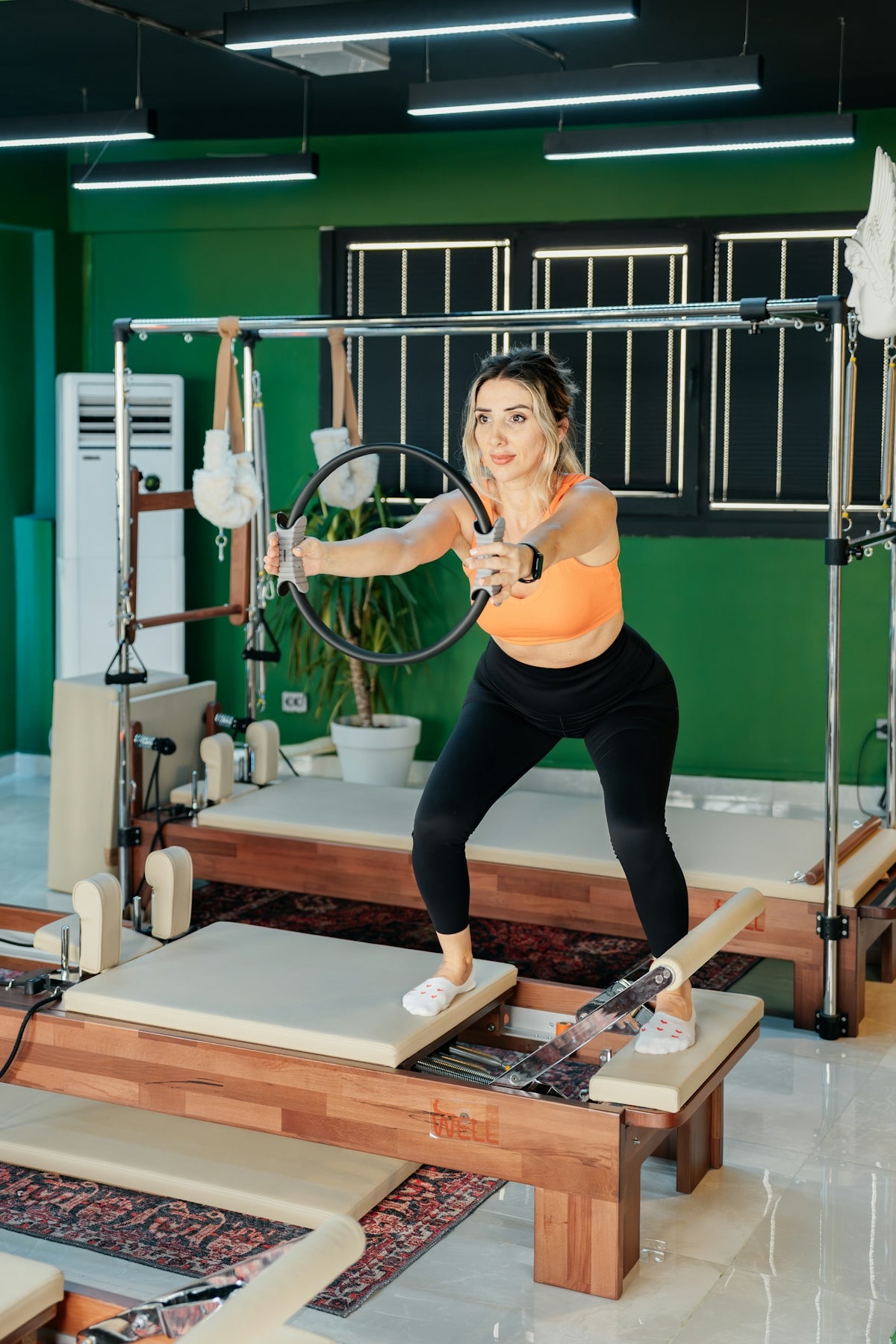 Woman exercises with a pilates ring on a machine.
