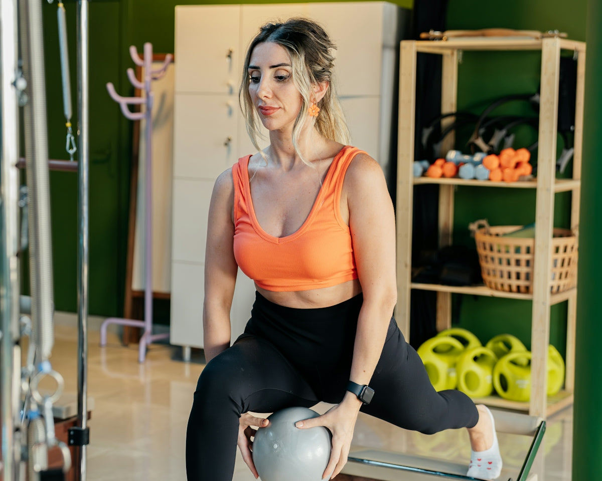 Woman does pilates exercise with a ball.