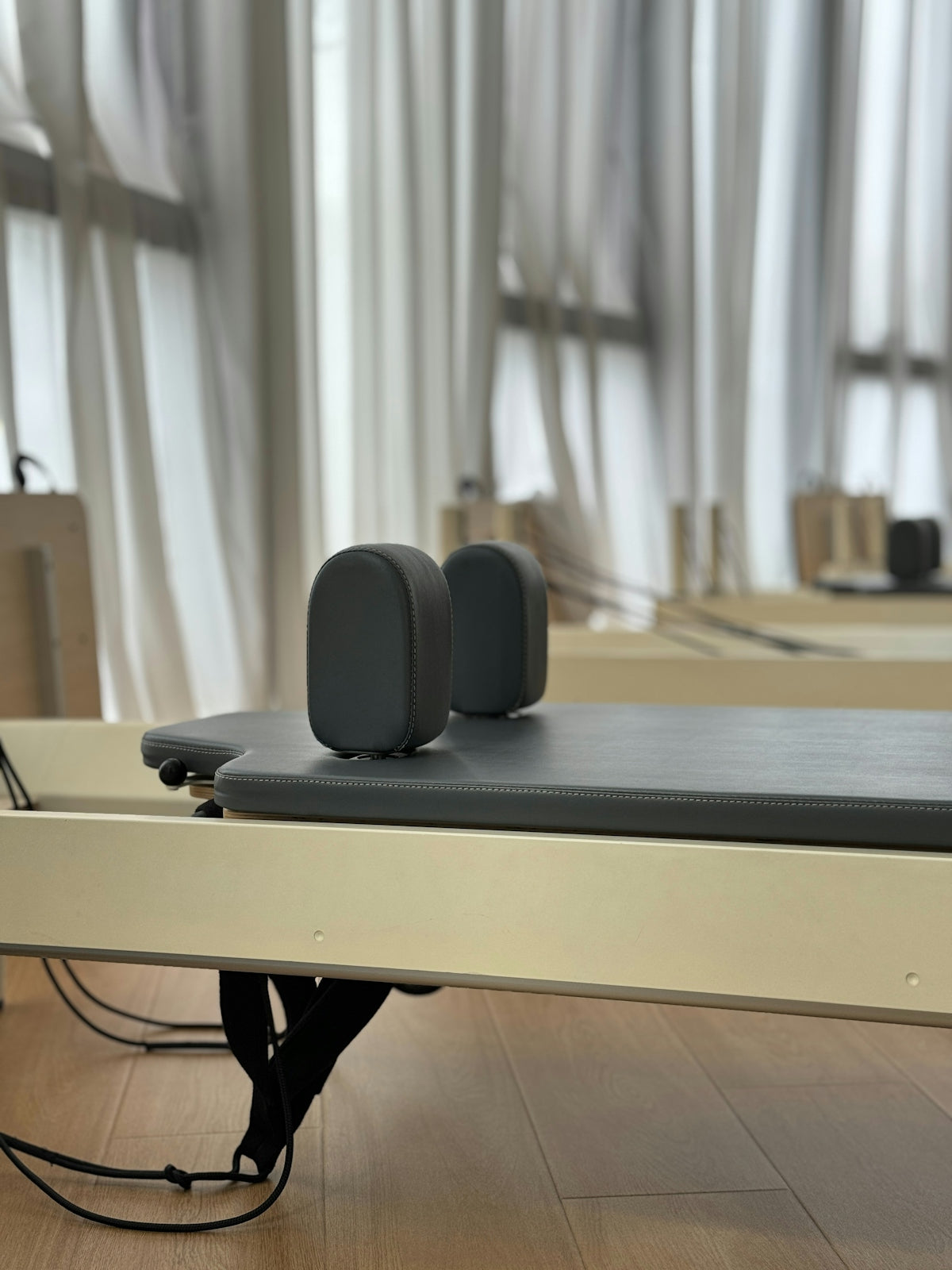 Pilates reformer with padded headrest and straps.