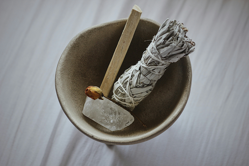 palo santo and sage smudge sticks in a smudging bowl