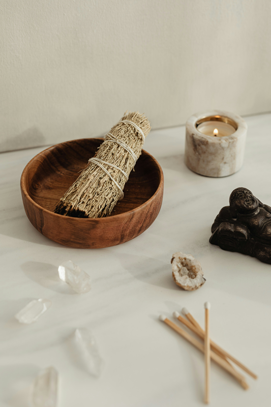 smudge stick in timber bowl with crystals and candle