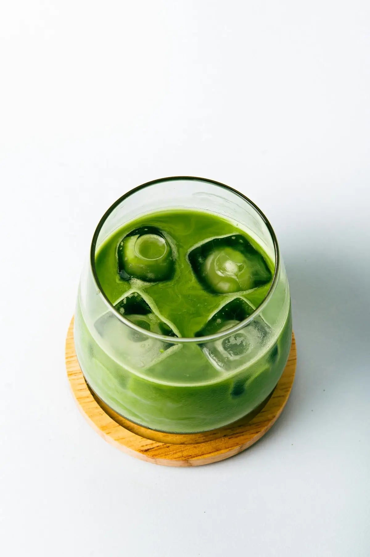 a green drink with ice cubes in it