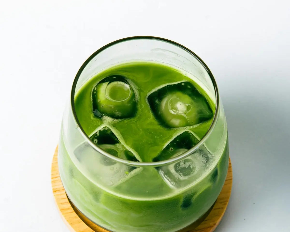 a green drink with ice cubes in it