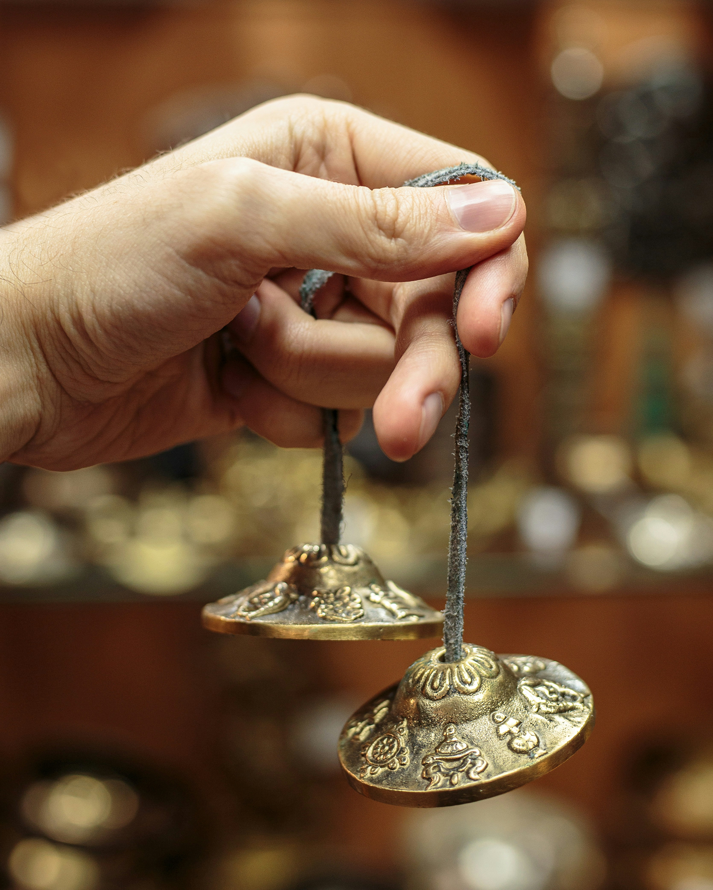 hand holding traditional tibetan chimes