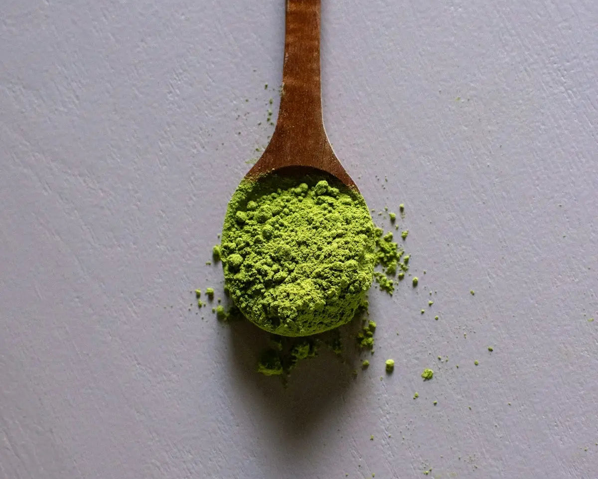 a wooden spoon filled with green powder
