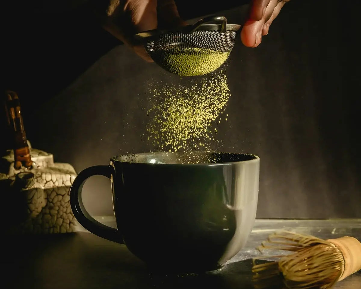 person pouring water on black ceramic mug