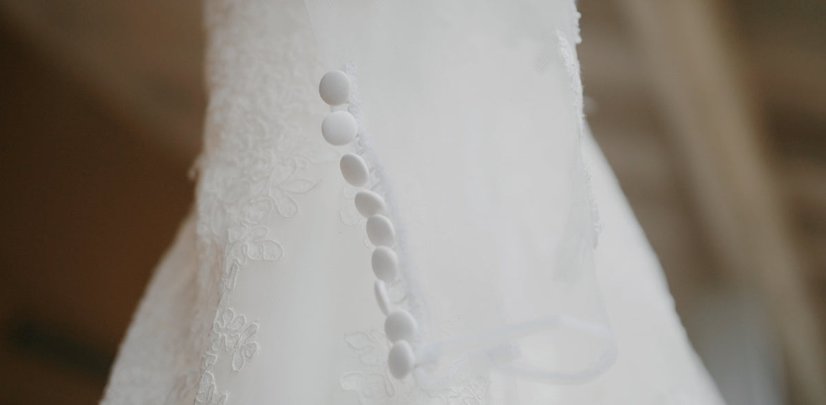 a close up of a white dress with beads on it