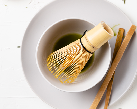 bowl of matcha with traditional whisk and powder