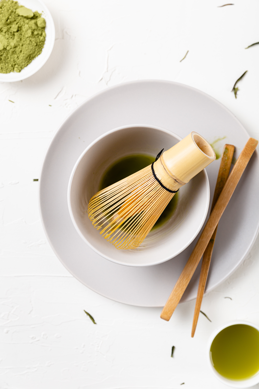 bowl of matcha with traditional whisk and powder