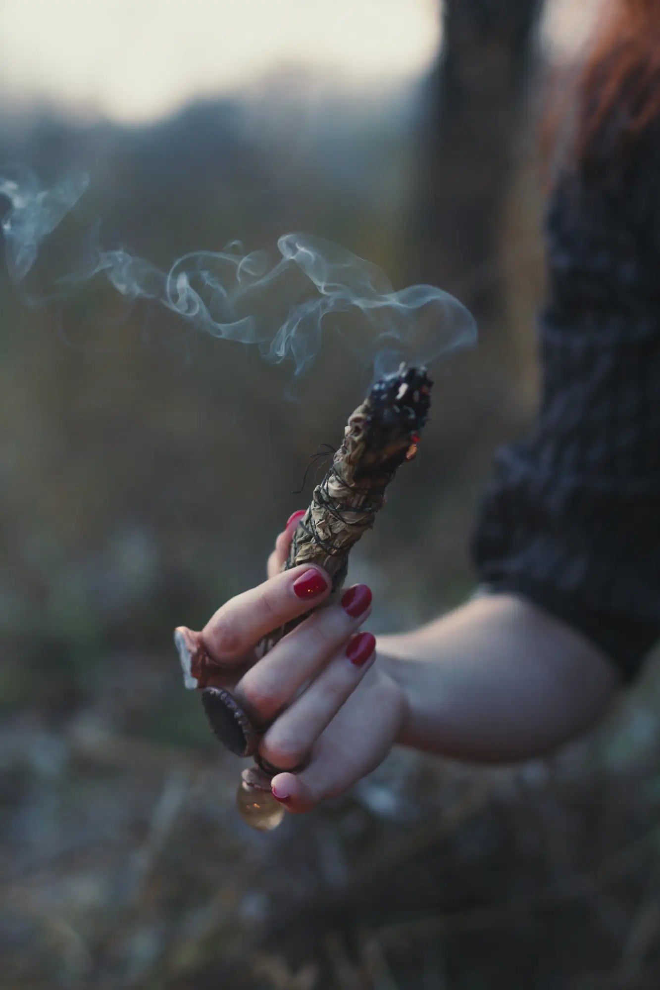 woman using herbal smudge stick