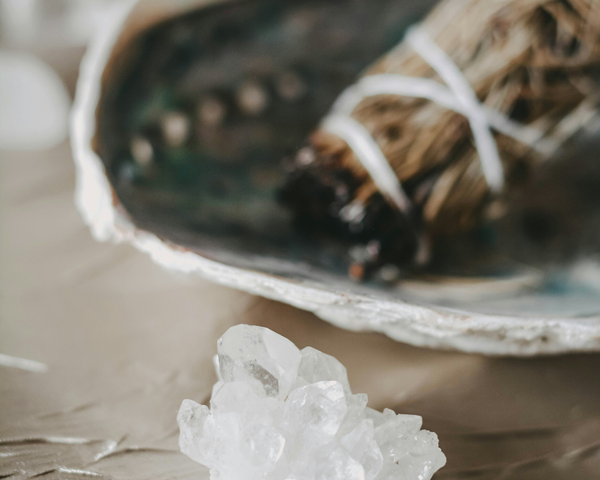 white sage smudge stick with bowl and quartz crystal