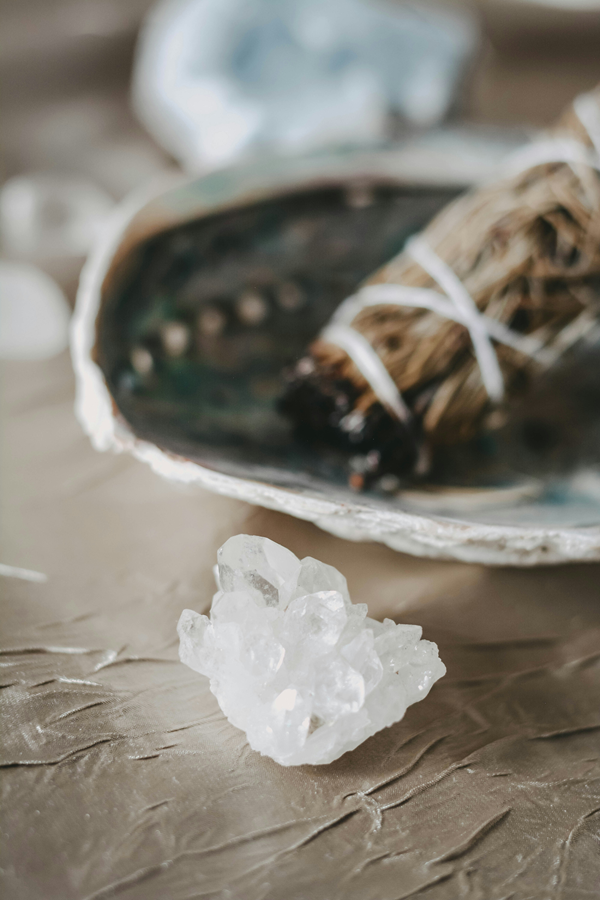 white sage smudge stick with bowl and quartz crystal