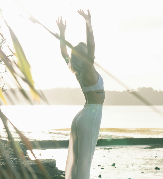 woman doing sun salutation at rockpools