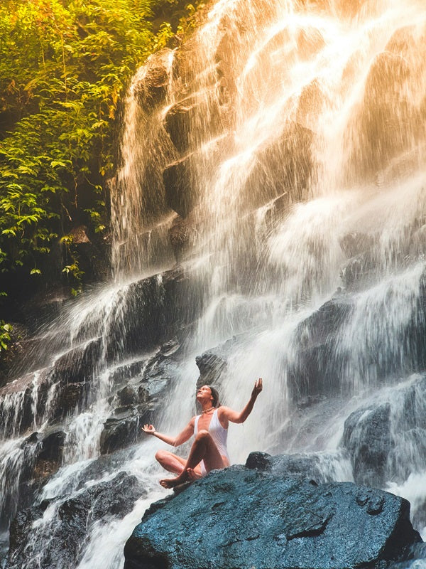 woman meditation in front of waterfall