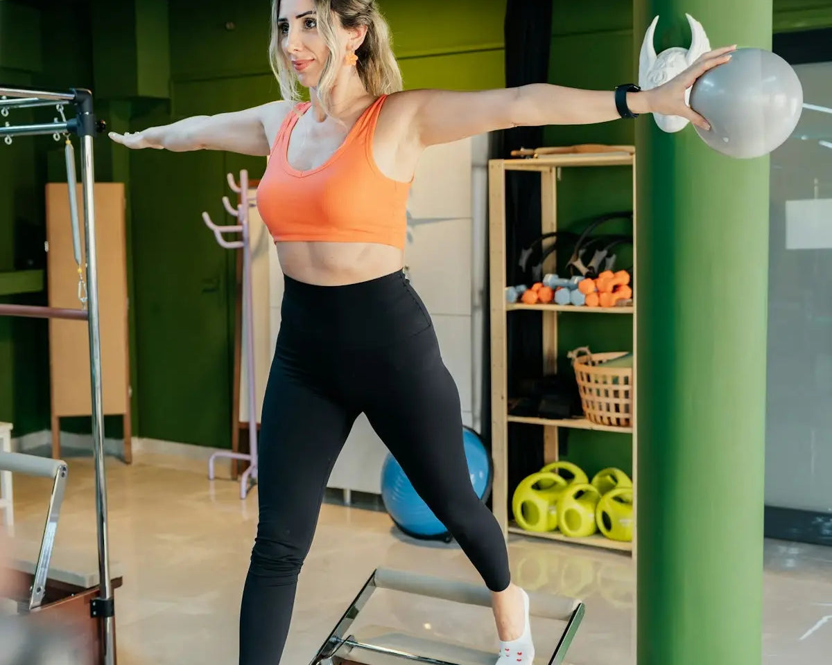 Woman exercises on a pilates machine with a ball