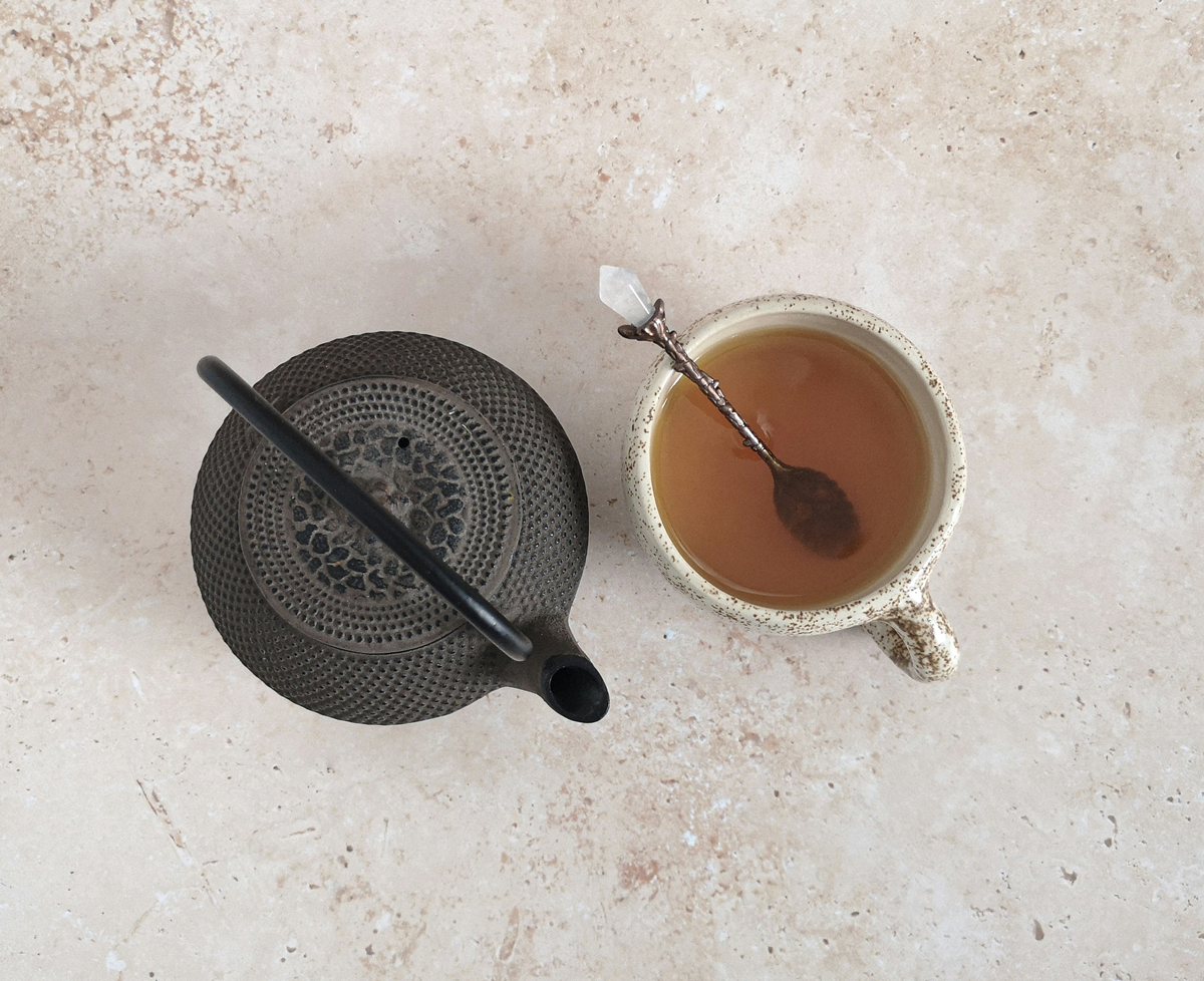 cast iron teapot with cup of herbal tea