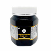 Black jar of Australian Manuka Honey MGO 100+ with yellow label and white lid