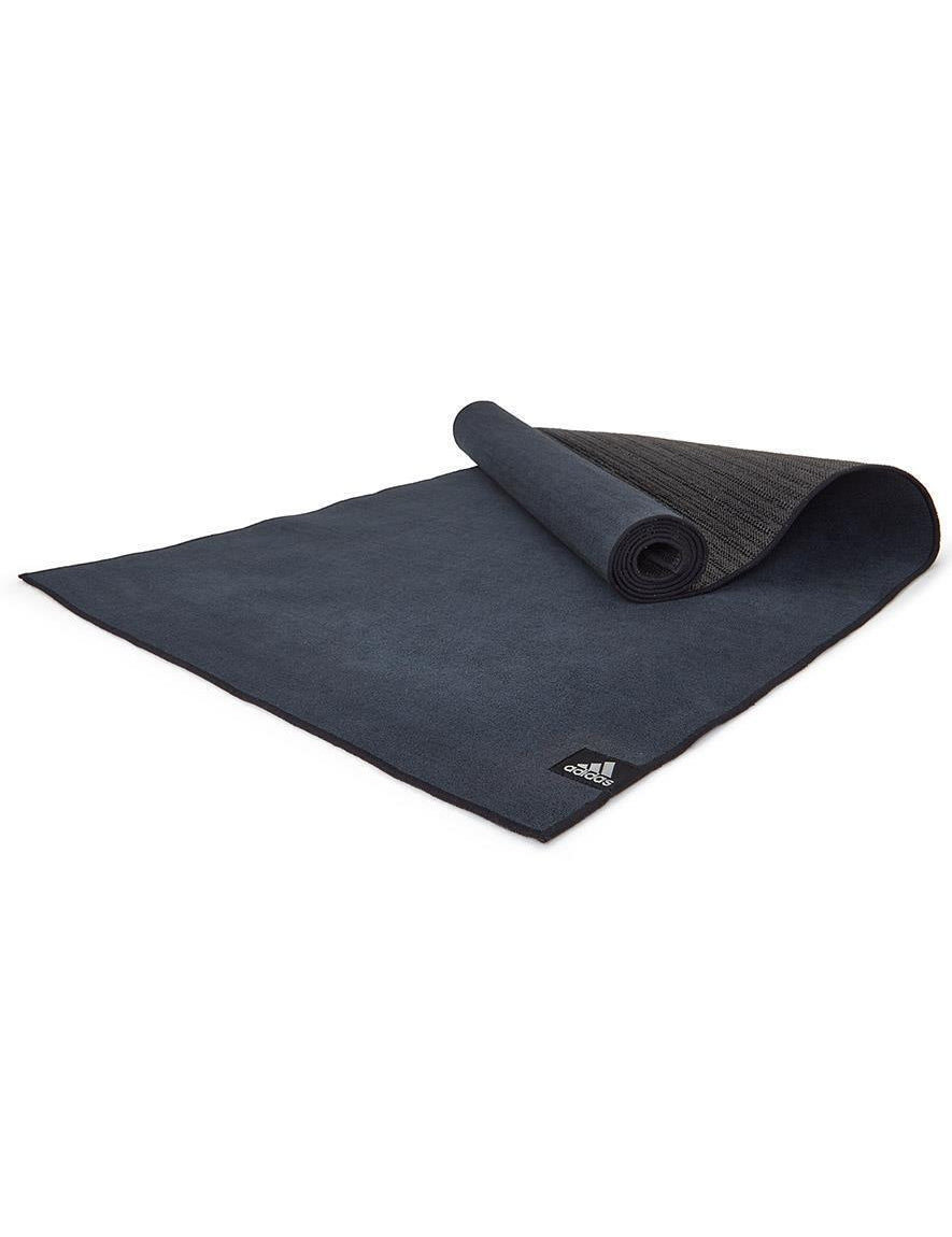 Black Adidas Hot Yoga Mat with webbed non-slip base partially rolled up for exercise