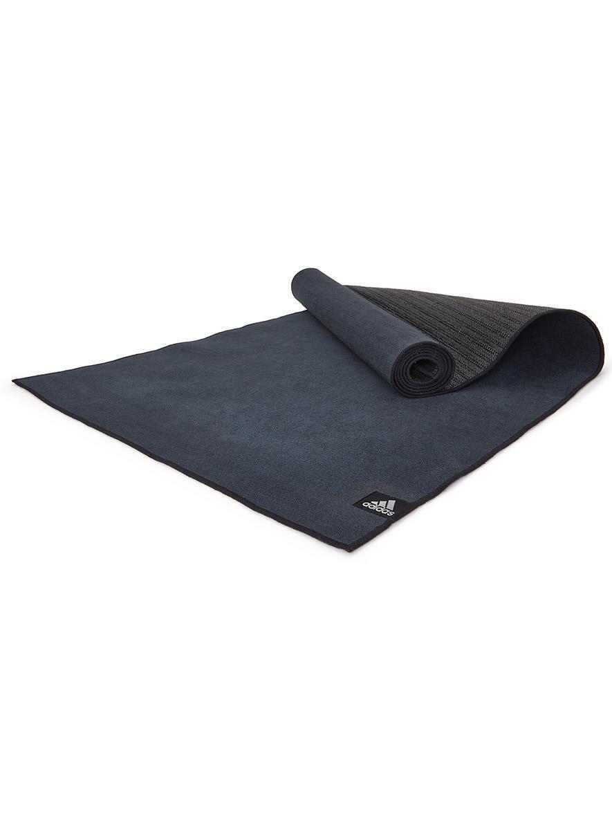 Black Adidas Hot Yoga Mat with webbed non-slip base partially rolled up for exercise