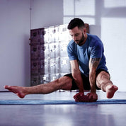 Athletic person in a split position on an Adidas Eco Yoga Block for home fitness